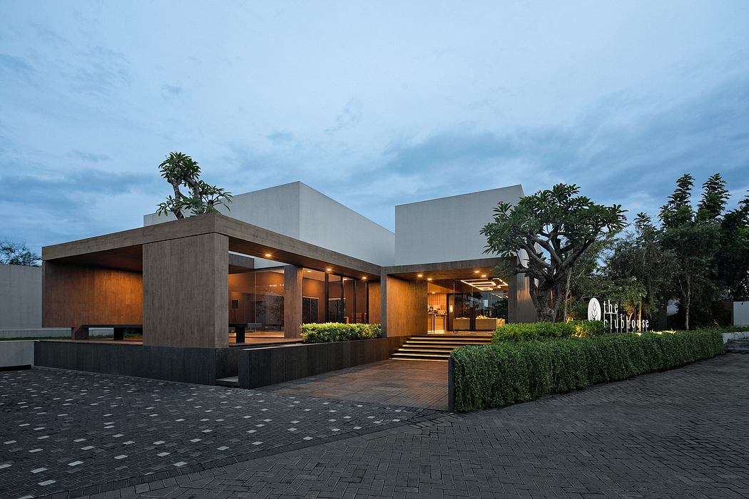 Sleek, modern architecture with wooden accents, planters, and illuminated entryway.