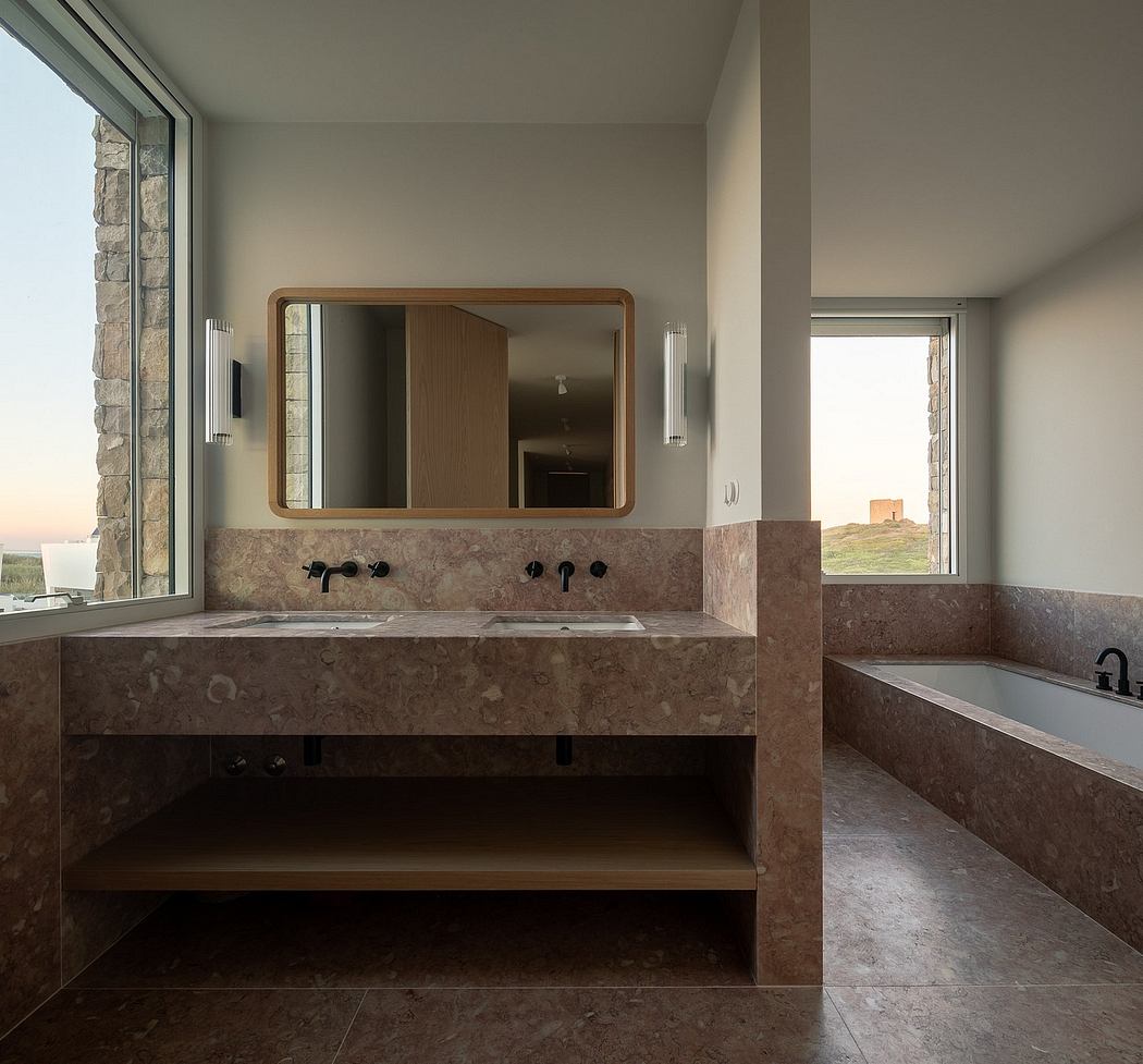 A modern bathroom with stone vanity, large mirror, and sleek lighting fixtures.