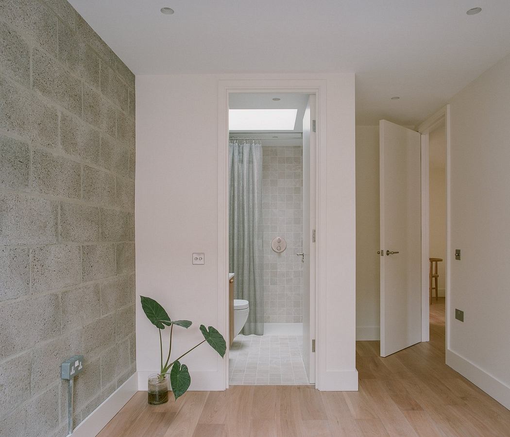 Minimalist modern interior with clean white walls, tiled bathroom, and hardwood floors.