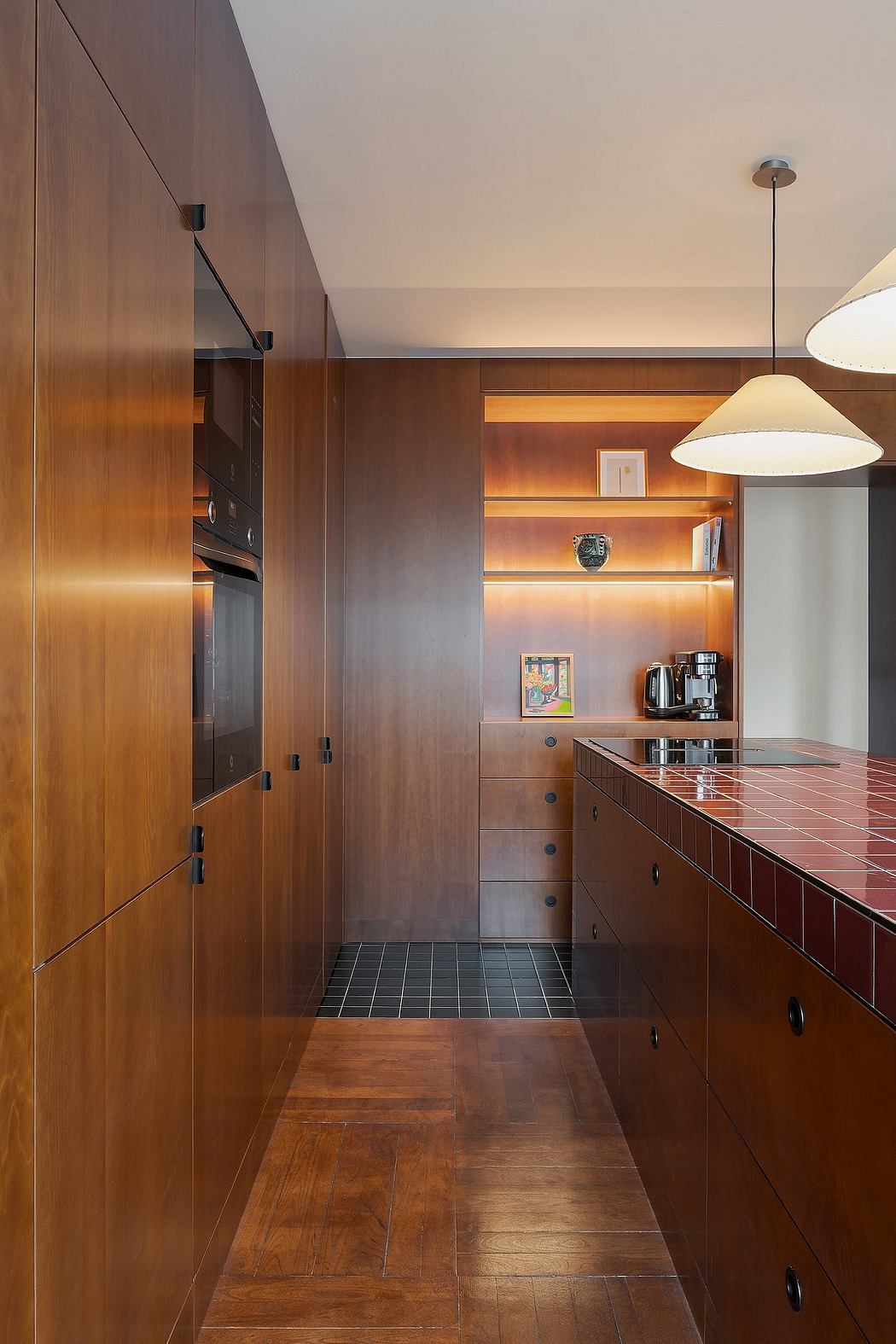 A modern kitchen with wooden cabinetry, sleek appliances, and warm lighting features.