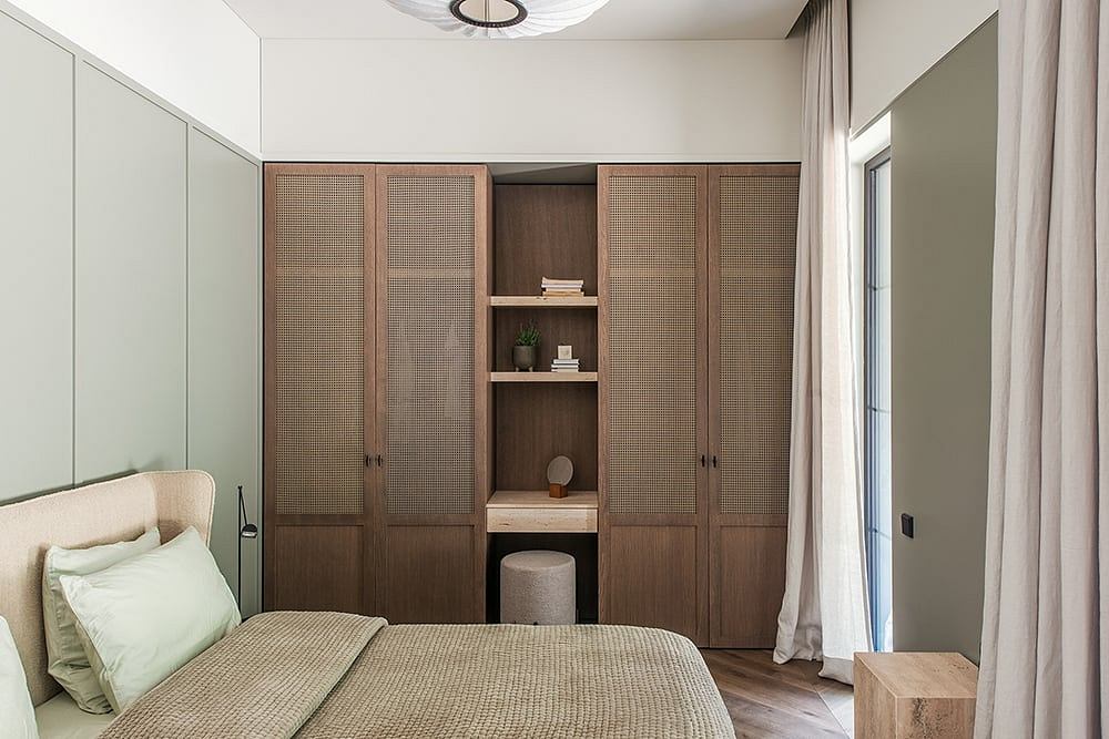 Cozy bedroom with wooden built-in cabinets, shelves, and a comfortable bed.