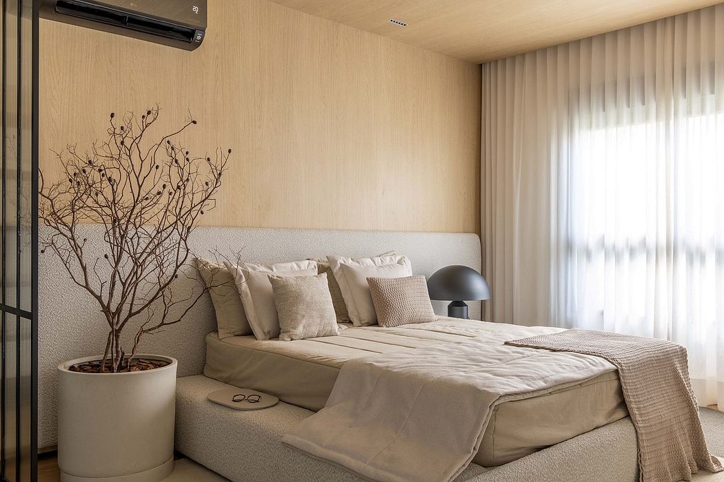 Minimalist bedroom with natural textures, warm lighting, and a decorative leafless tree.