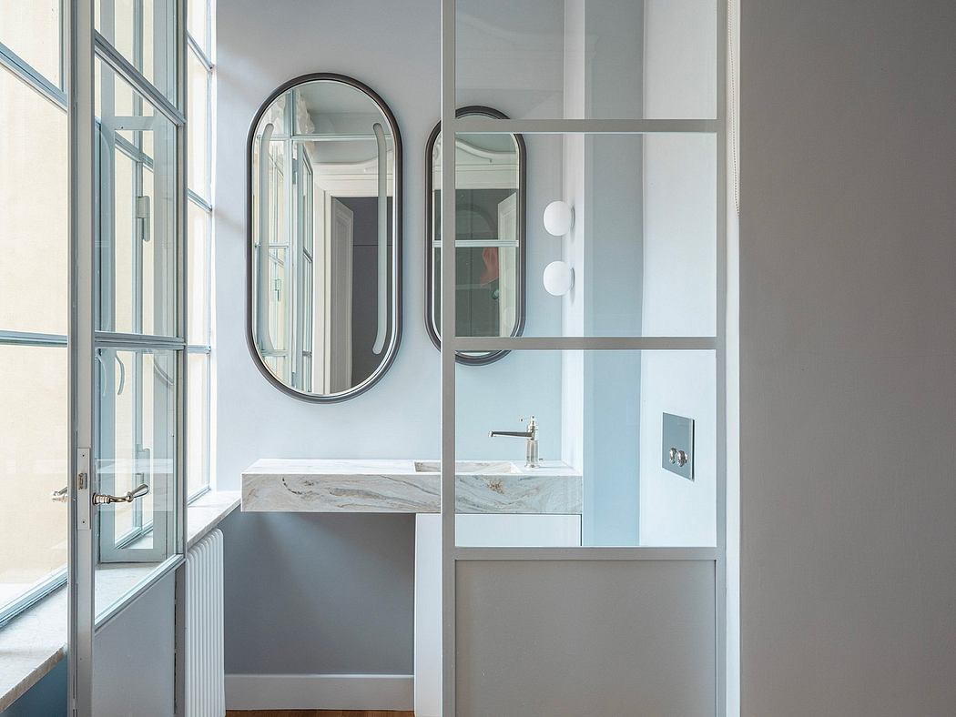 Minimalist bathroom design with sleek mirror, vanity, and glass partition.