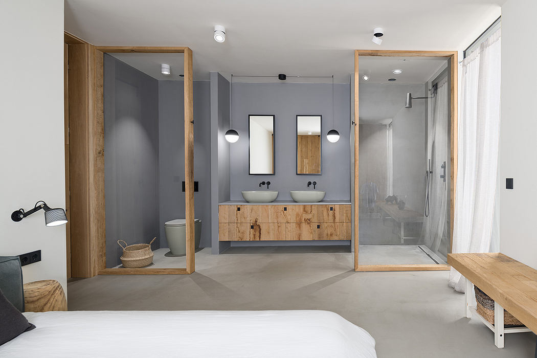 Spacious modern bathroom with gray walls, wood vanity, and glass shower enclosure.