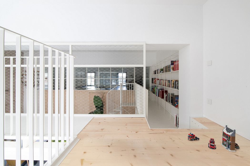 Bright, open-plan interior with white walls, wooden floors, and metal railing details.