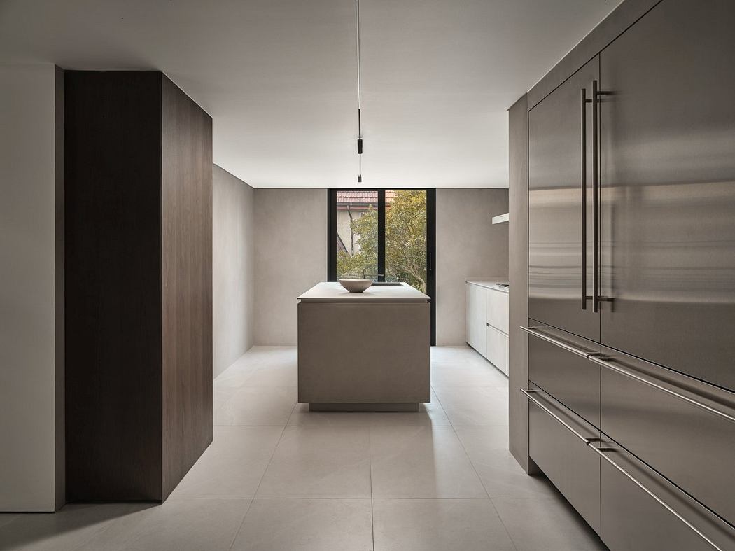 A minimalist kitchen design with sleek cabinetry, a central island, and large windows.