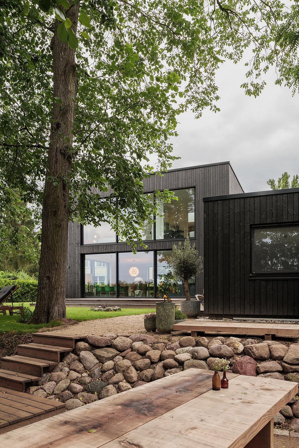 Striking modern architecture with wood, stone, and expansive windows blending seamlessly with nature.