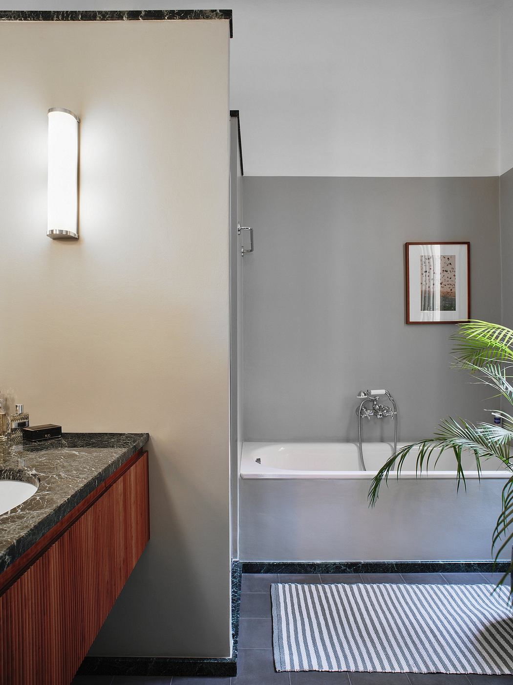 Sleek modern bathroom with marble vanity, tub, and botanical accents.