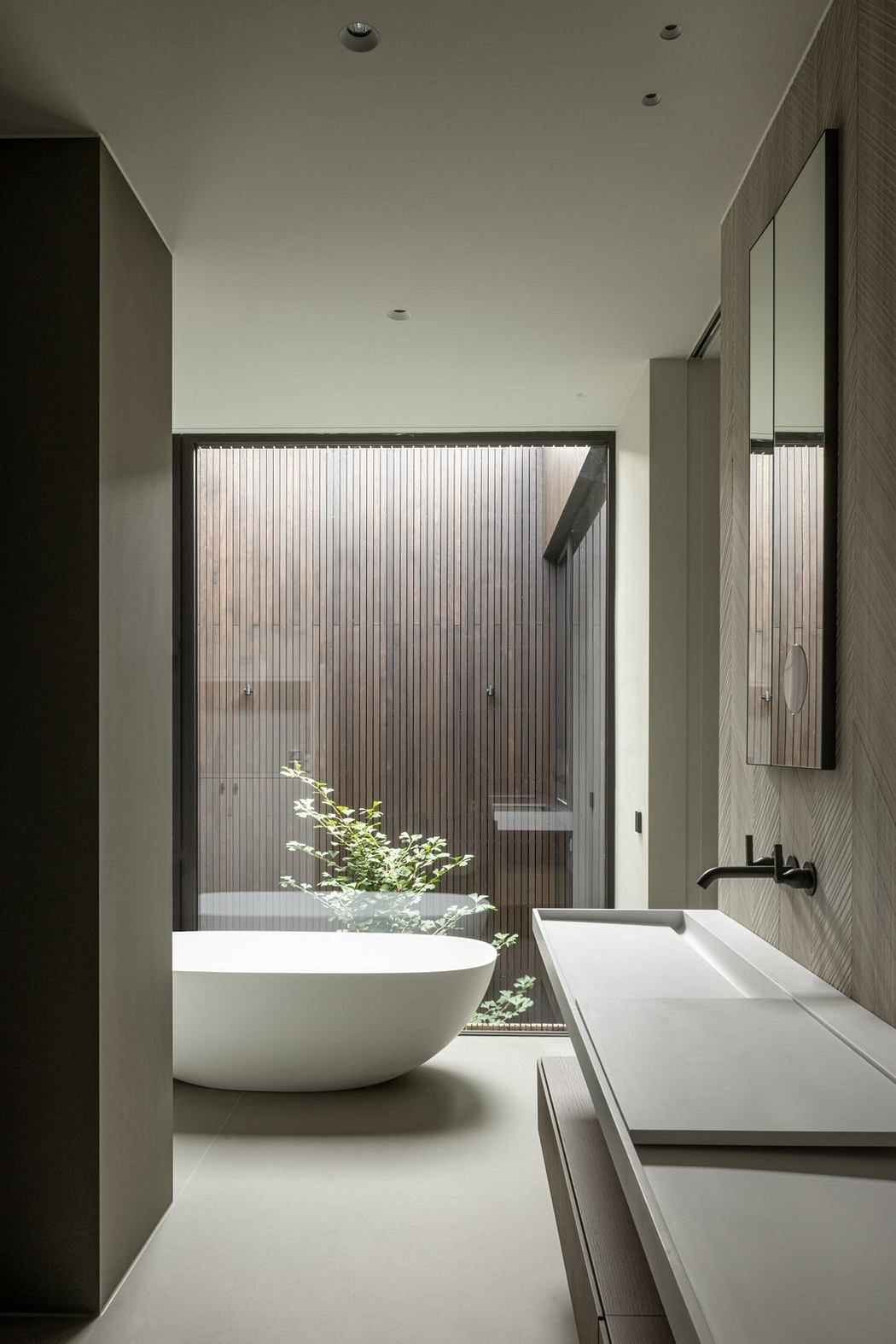 A modern bathroom with a freestanding bathtub, sleek vanity, and natural lighting.