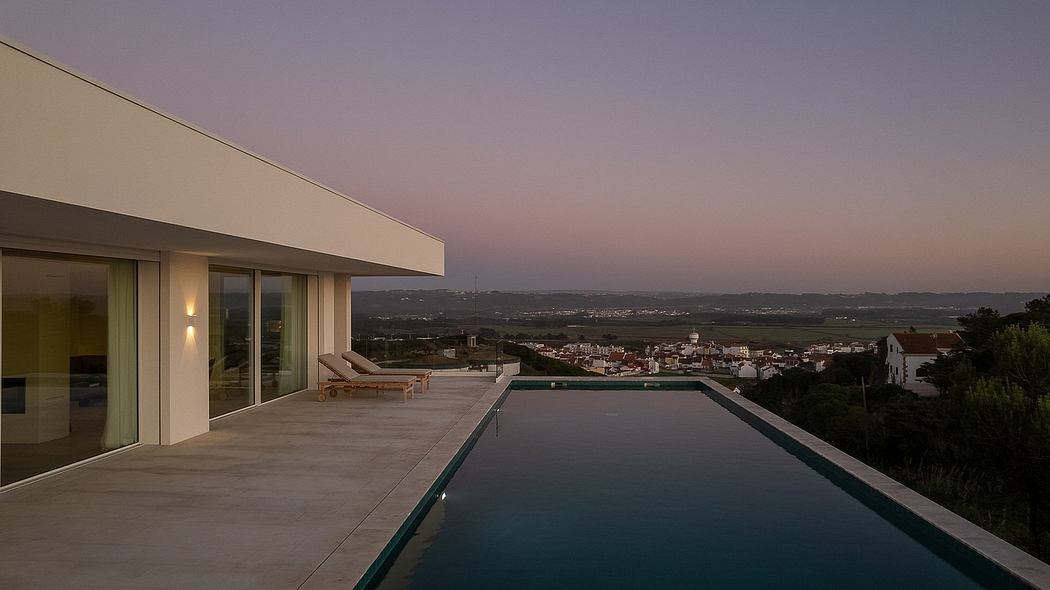 Sleek modern home with floor-to-ceiling windows, infinity pool, and stunning cityscape view.