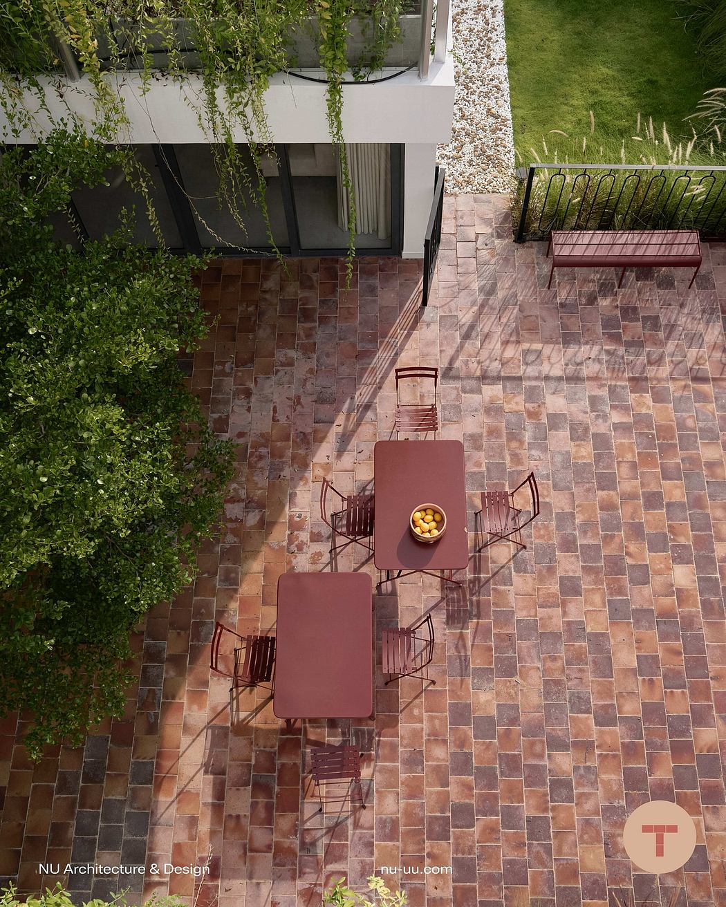 Outdoor courtyard with tiled floor, modern furniture, and lush greenery surrounding the space.