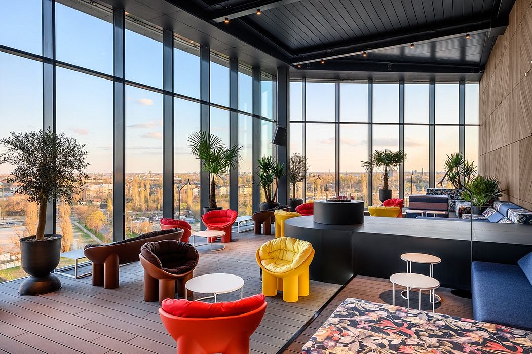 Vibrant modern lounge with colorful furnishings, floor-to-ceiling windows, and scenic city view.