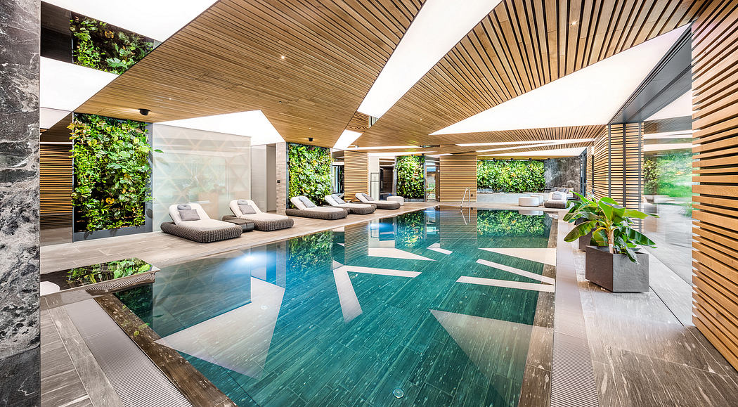 Stunning modern indoor pool surrounded by a wooden ceiling and lush greenery.