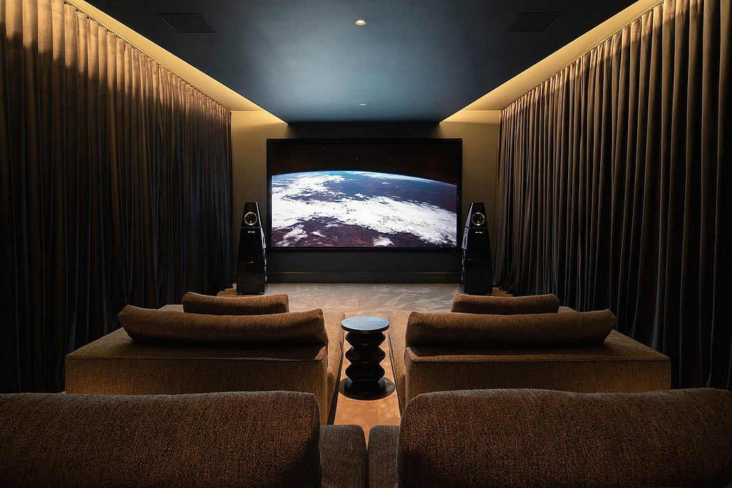 A spacious home theater with plush brown couches, a large screen, and sophisticated lighting.