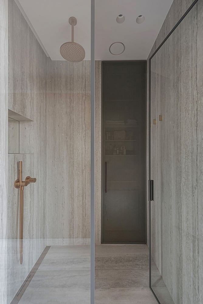 Sleek, minimalist bathroom with glass shower enclosure and recessed lighting.