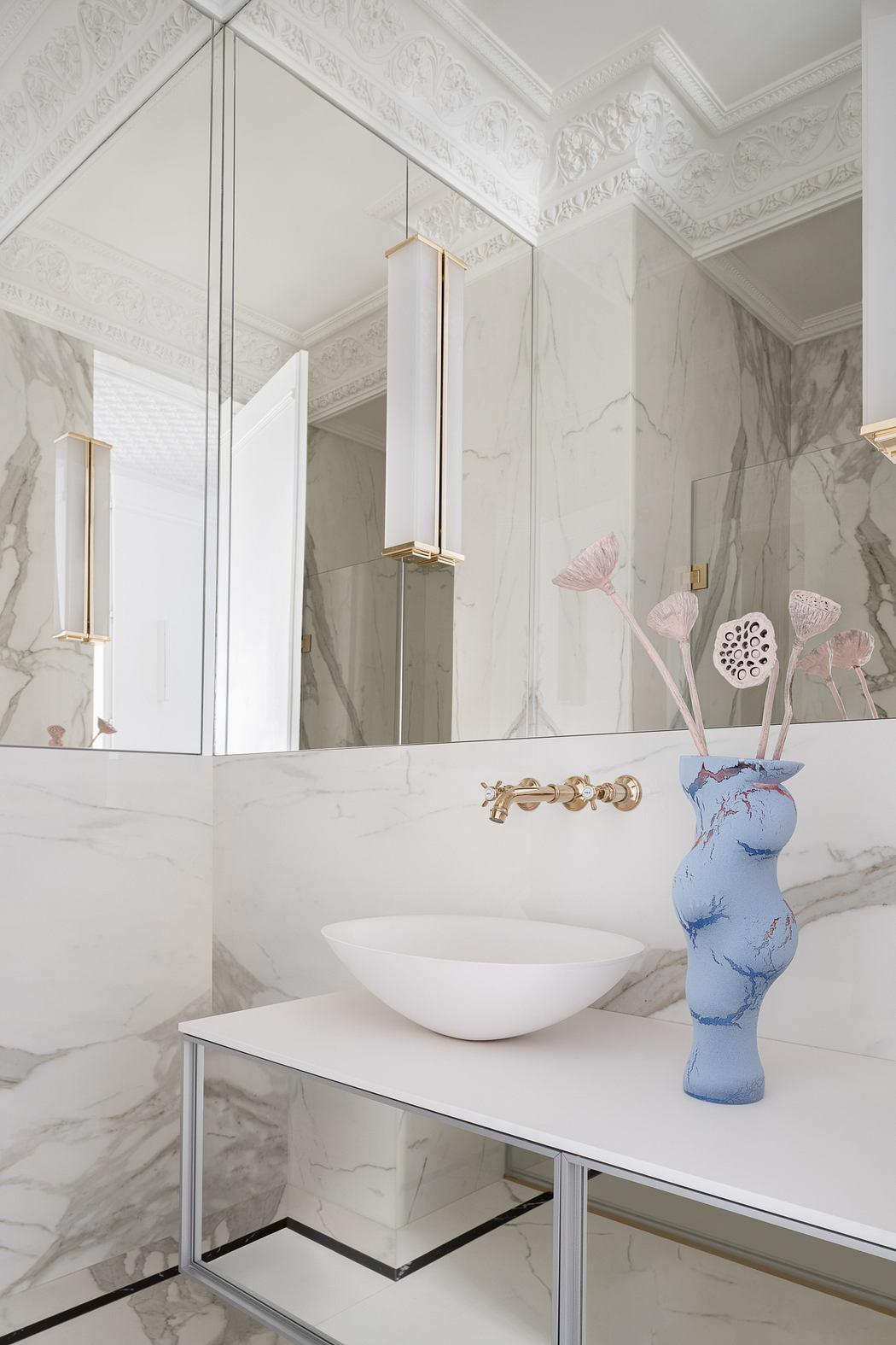 Elegant marble bathroom with intricate ceiling moldings and modern vanity fixtures.