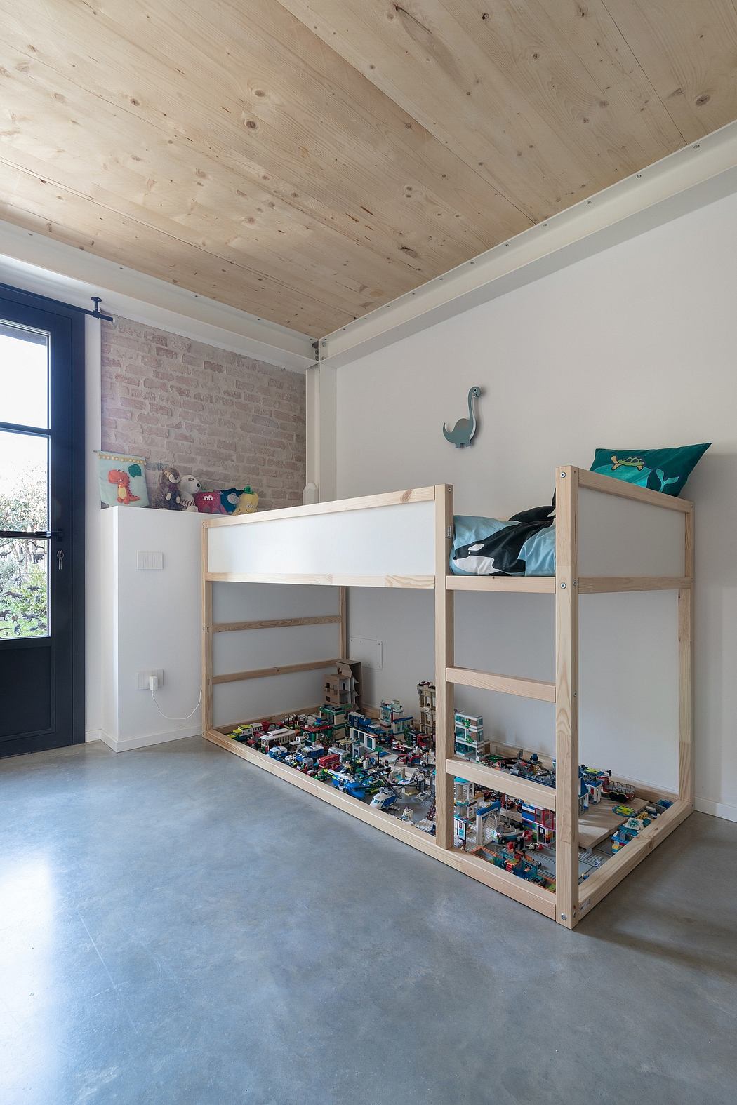 Rustic wooden ceiling contrasts with modern brick wall and custom bunk bed storage.