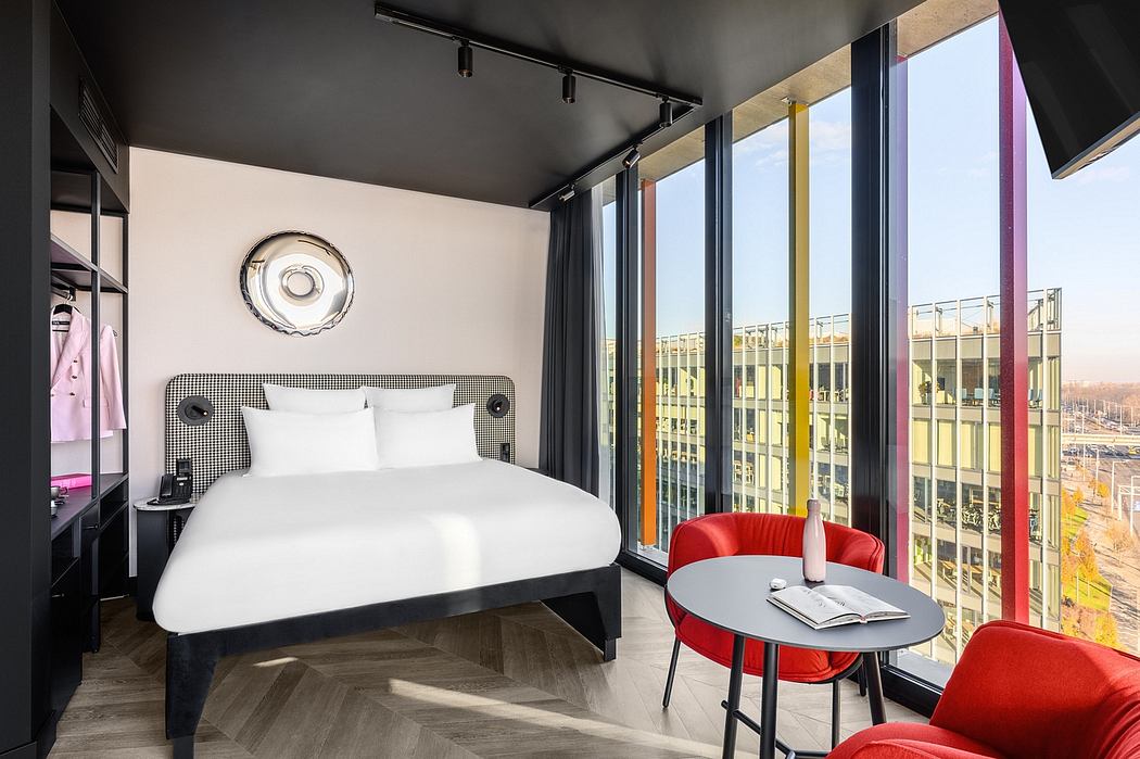 Modern hotel room with sleek black and white decor, floor-to-ceiling windows, and vibrant red accents.