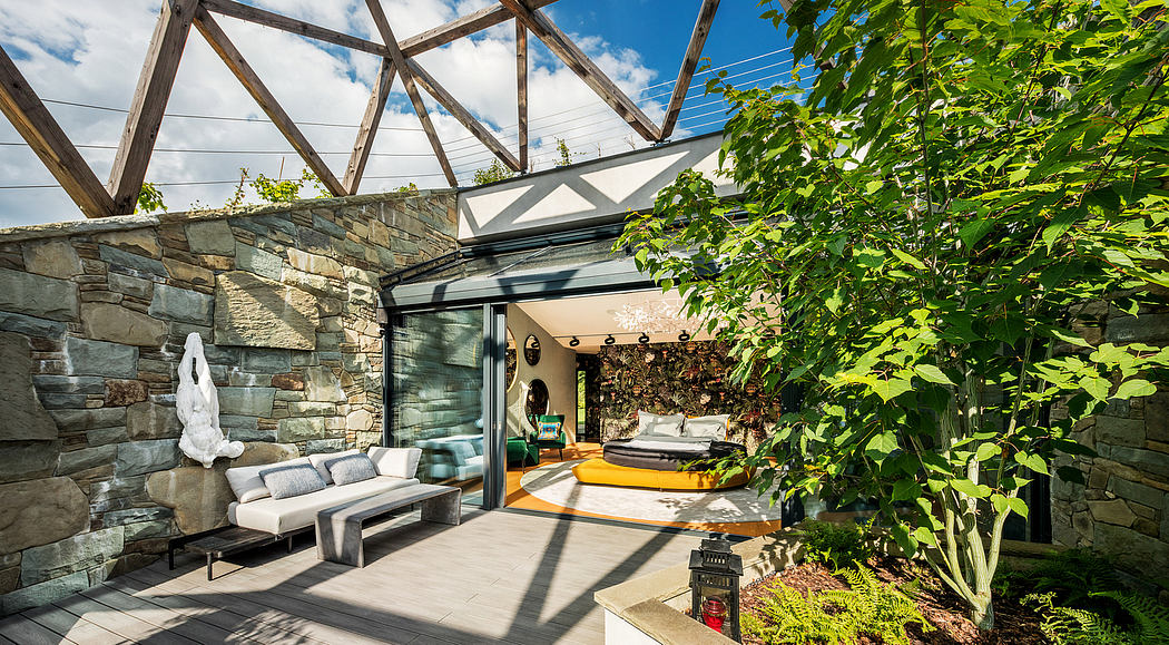A modern architectural marvel with stone walls, glass walls, and lush greenery.