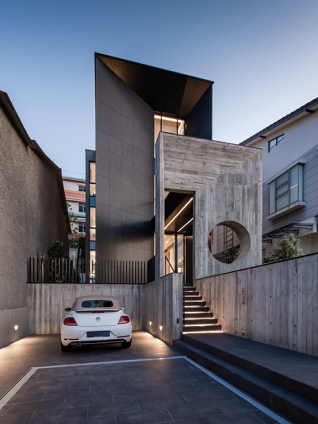 Striking modern architecture with sleek gray exterior, circular window, and inviting entryway.