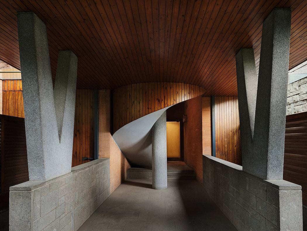 A striking wooden ceiling with curved concrete walls, creating an architectural passage.