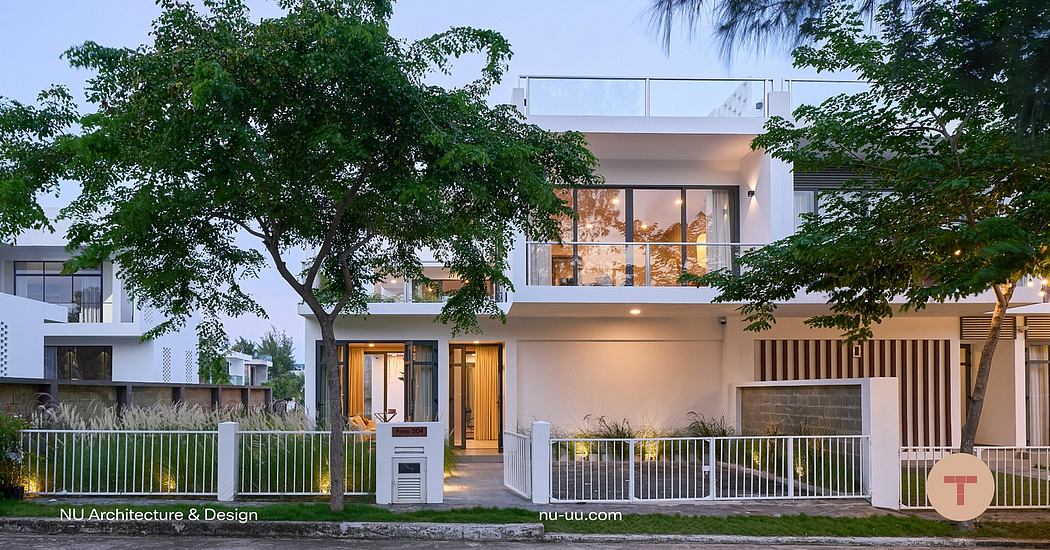 Modern two-story home with clean lines, large windows, and lush surrounding greenery.