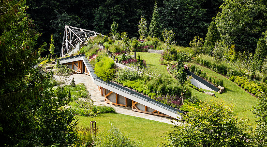 An impressive architectural structure with wooden elements amidst a lush, verdant landscape.