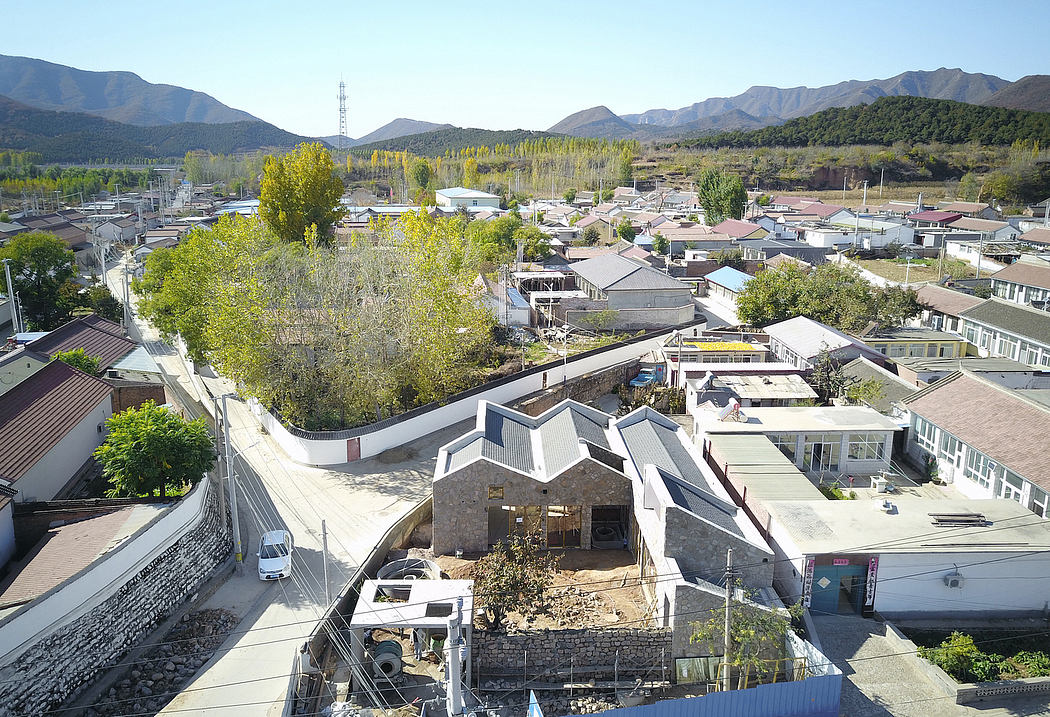 Panoramic view of a quaint town nestled between mountains, showcasing diverse architectural styles.