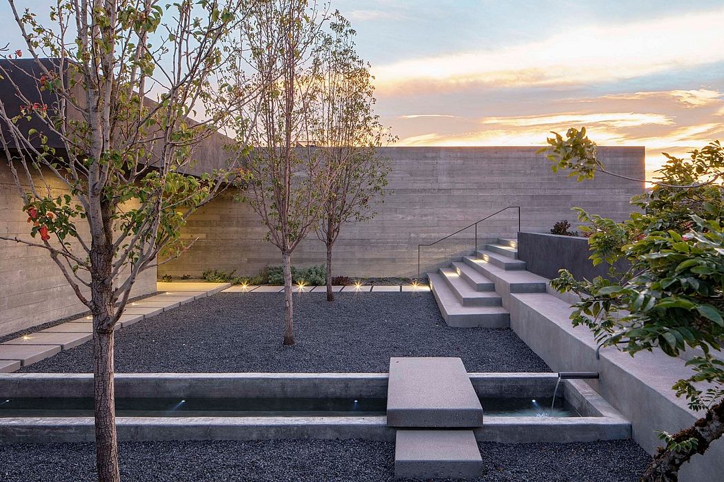 Minimalist outdoor space with concrete steps, water feature, and architectural elements.