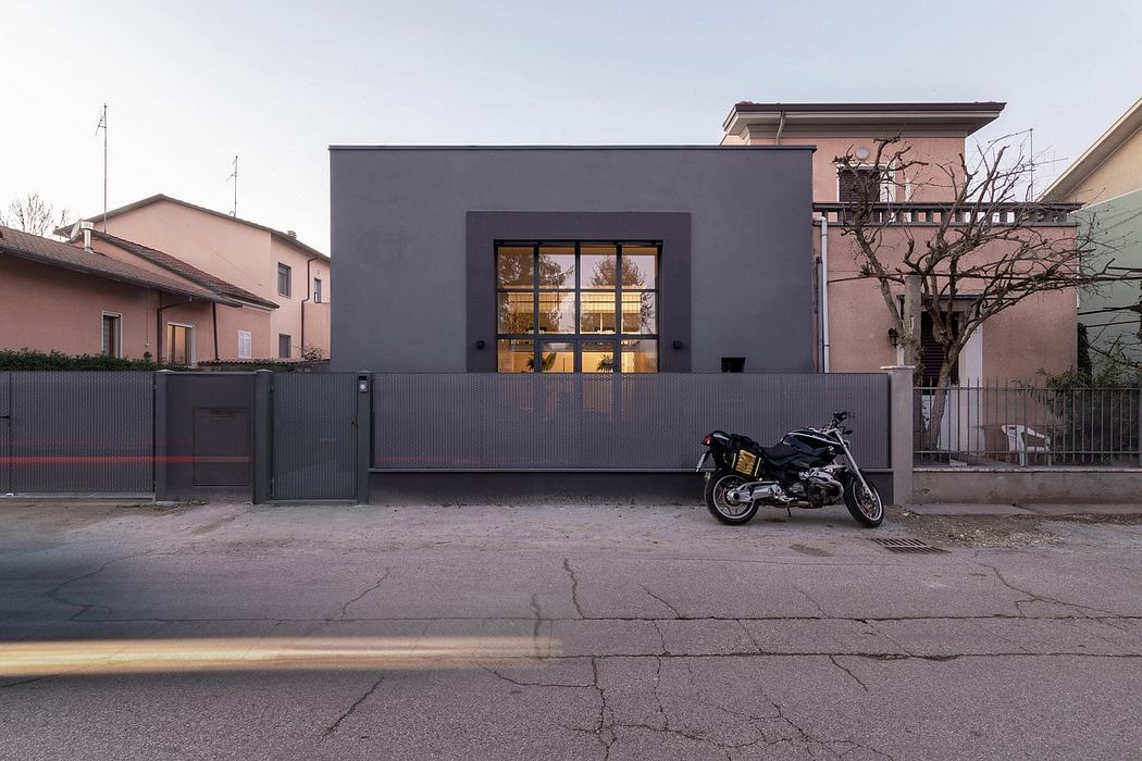 Striking modern building with sleek black exterior and large windows, complemented by a motorcycle.