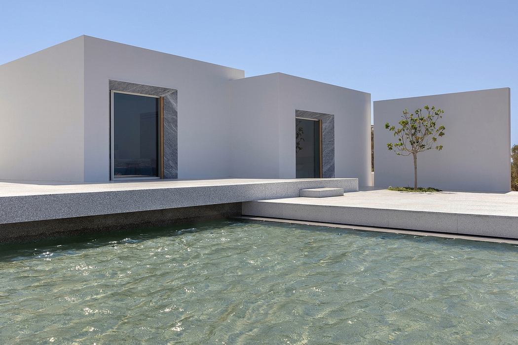 Sleek, minimalist architecture with a tranquil reflecting pool and a solitary tree.