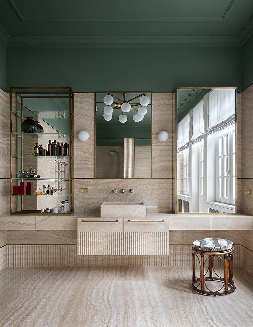 Luxurious bathroom with modern vanity, marble walls, and brass lighting fixture.