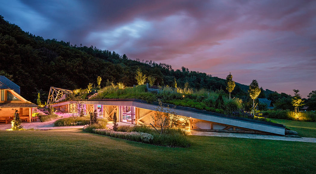 Cozy wooden structures nestled in a lush, illuminated landscape at sunset.