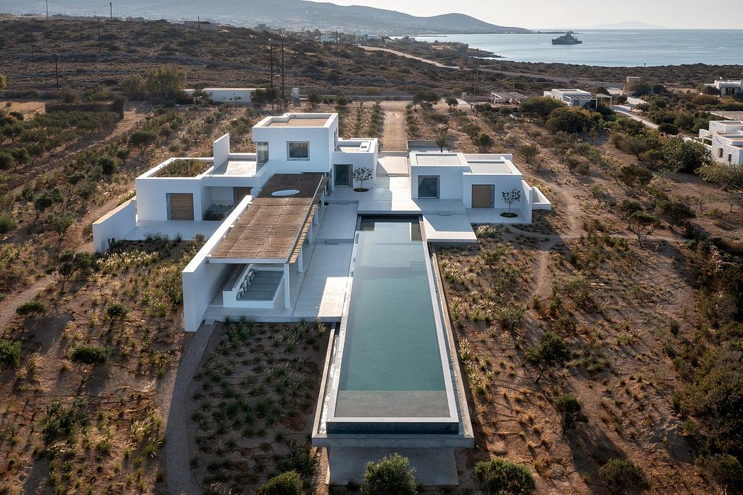 A modern, minimalist architecture with clean lines, terraces, and a reflecting pool.