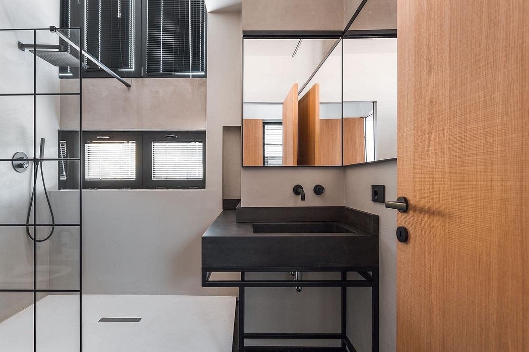 Sleek, minimalist bathroom with industrial-style fixtures, wooden accents, and geometric mirror.