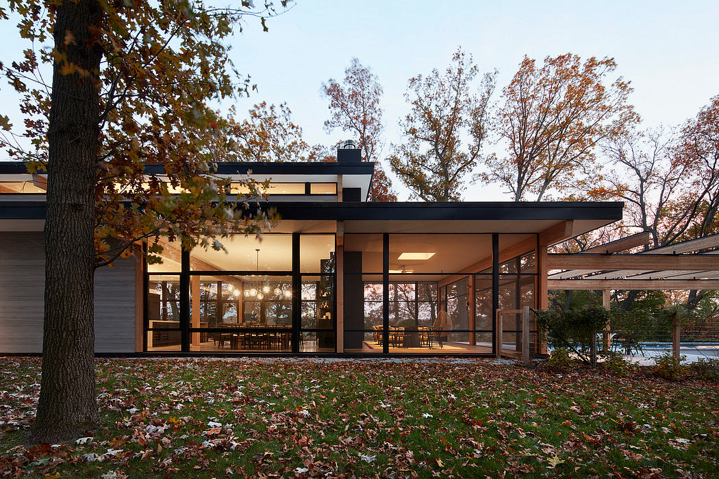 A modern glass and wood structure with large windows overlooking a lush landscape.