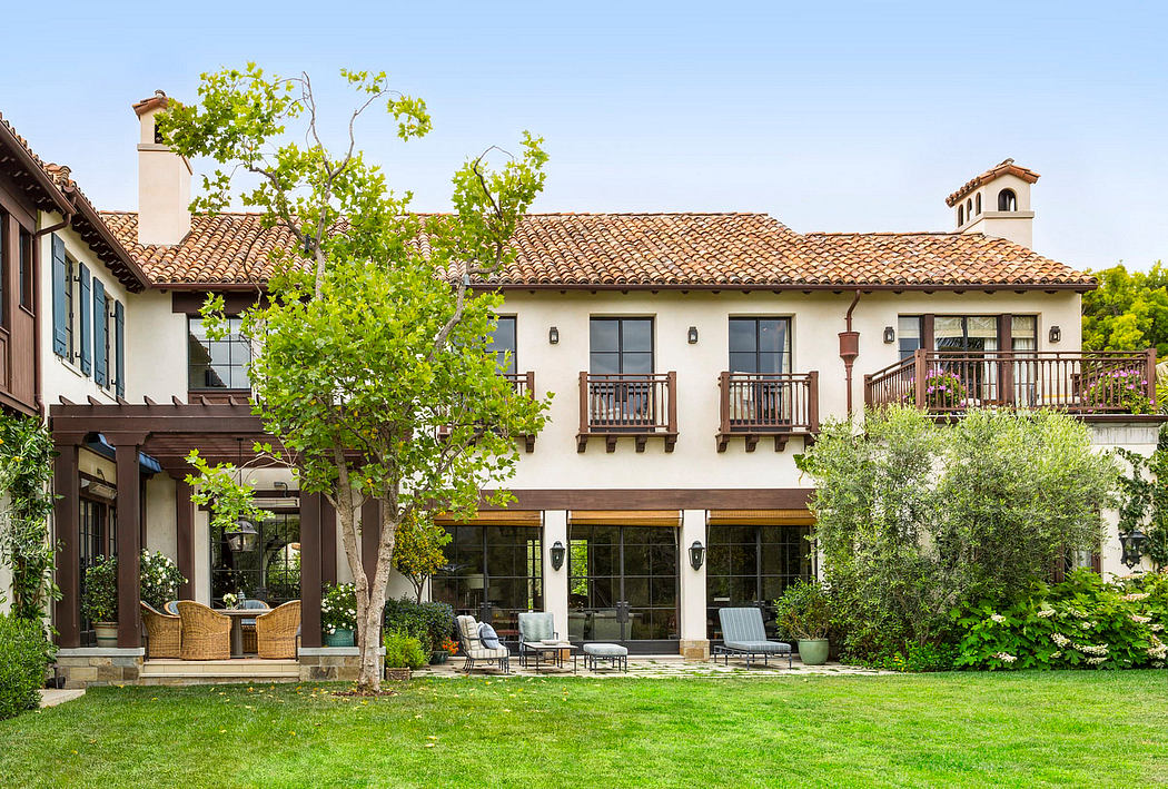 Beautiful Spanish-style villa with terracotta roof tiles, balconies, and lush landscaping.