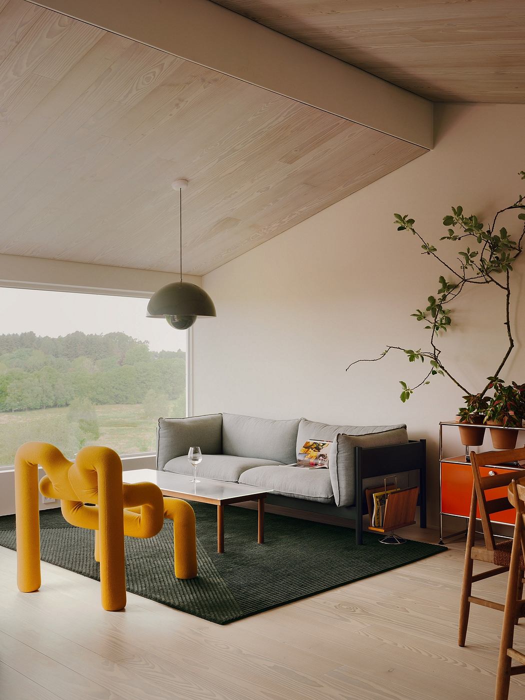Minimalist living room with wood-paneled ceiling, neutral sofa, and vibrant yellow chairs.