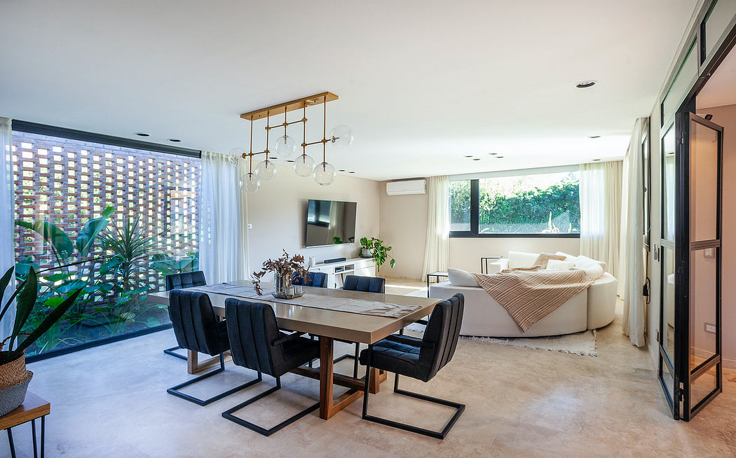 Spacious open-plan living area with contemporary furnishings, lighting, and large windows.