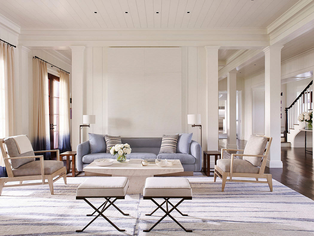 Spacious living room with high ceilings, neutral color scheme, and modern furnishings.