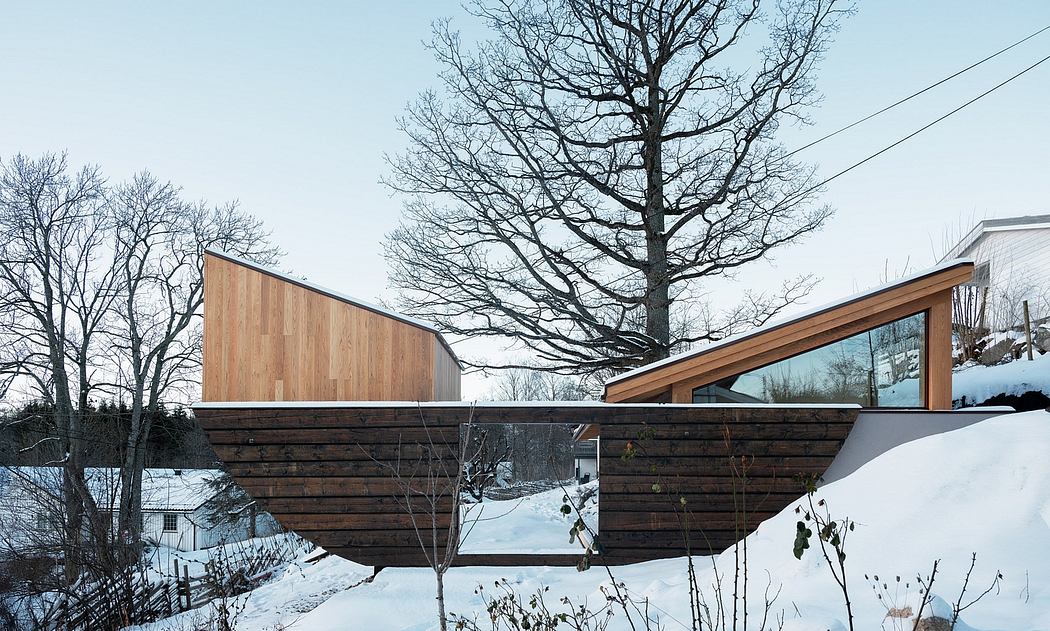Modular contemporary architecture with wooden and glass elements, set in a snowy landscape.