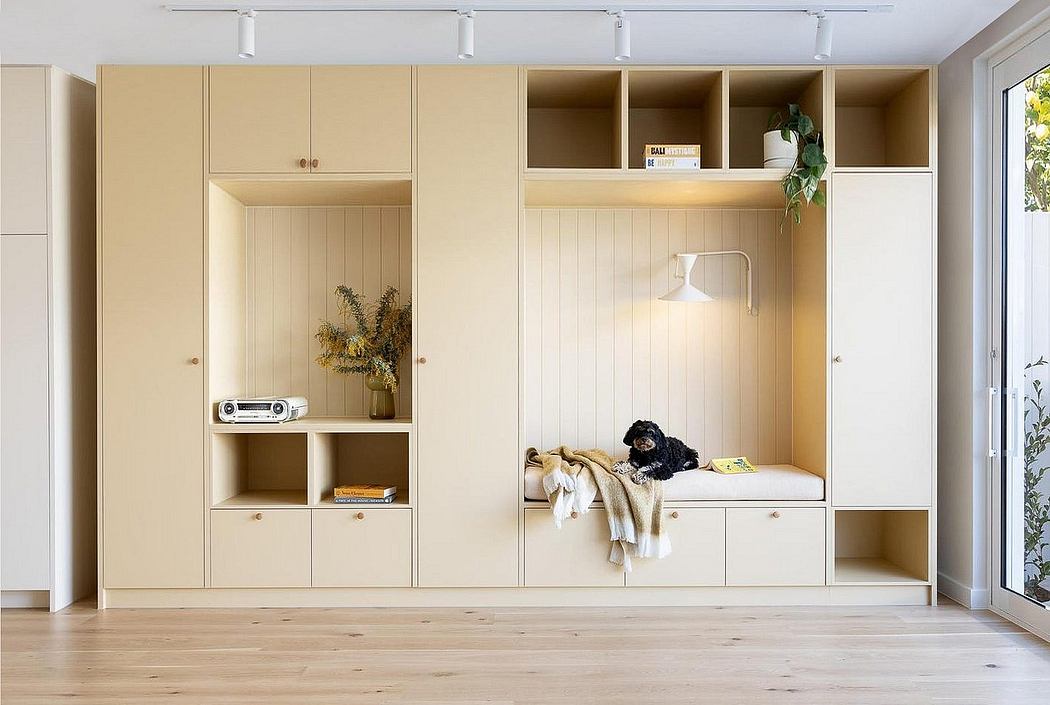 Minimalist built-in cabinetry with a cozy nook and a small dog relaxing on a cushion.