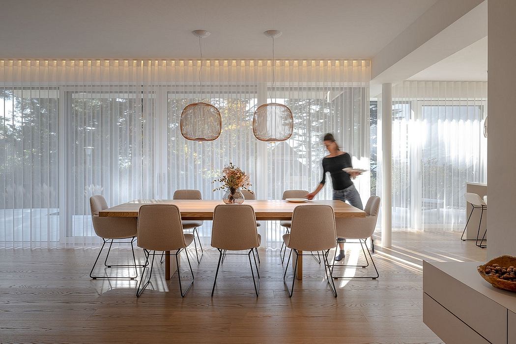 Spacious, light-filled dining room with wood table, modern chairs, and pendant lighting.