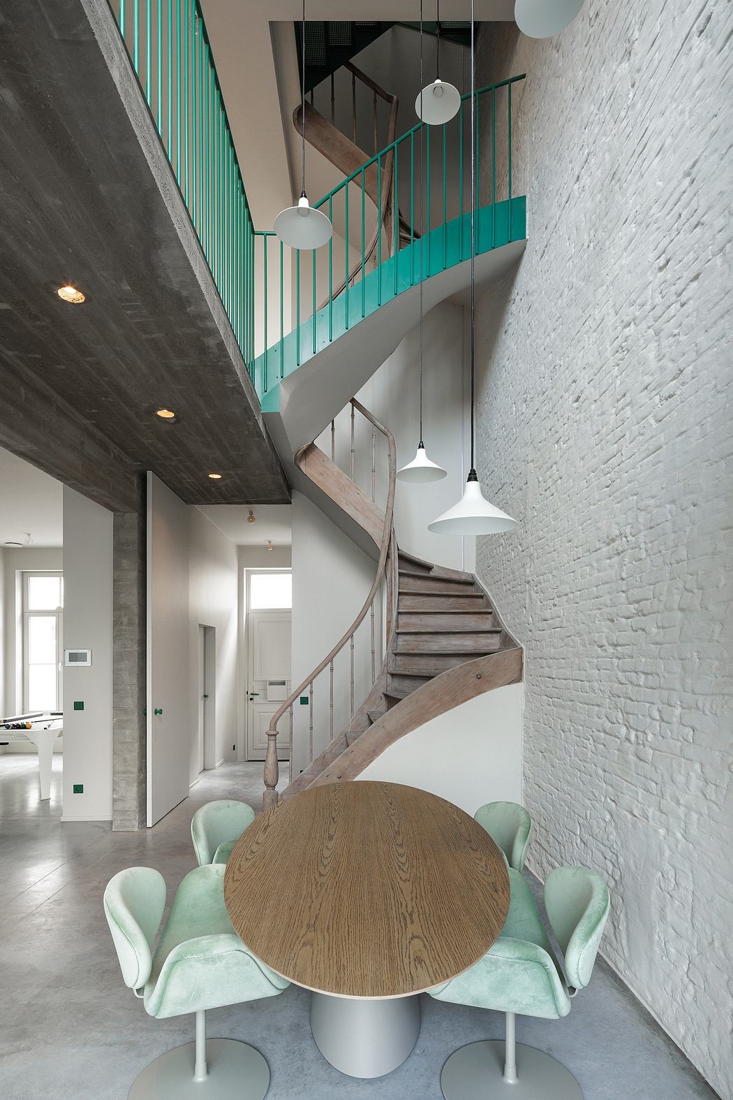 Modern staircase with turquoise railings and sleek, minimalist furnishings.
