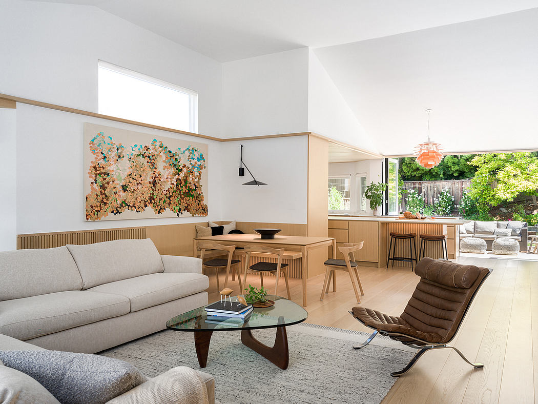 Bright, modern living space with natural wood furnishings, glass table, and colorful artwork.