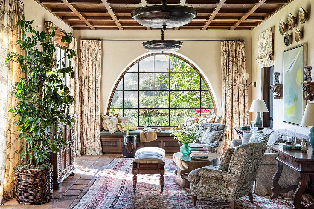 Cozy, sun-filled living room with arched window, wooden ceiling, and lush furnishings.