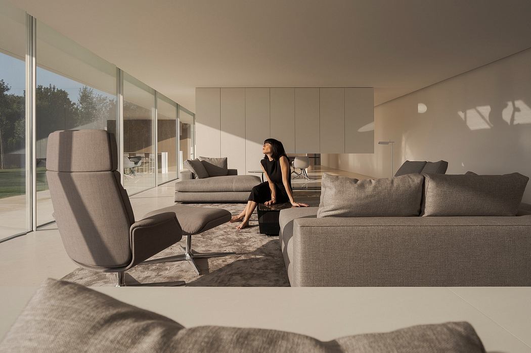 Sleek, modern living room with floor-to-ceiling windows, neutral color palette, and plush seating.