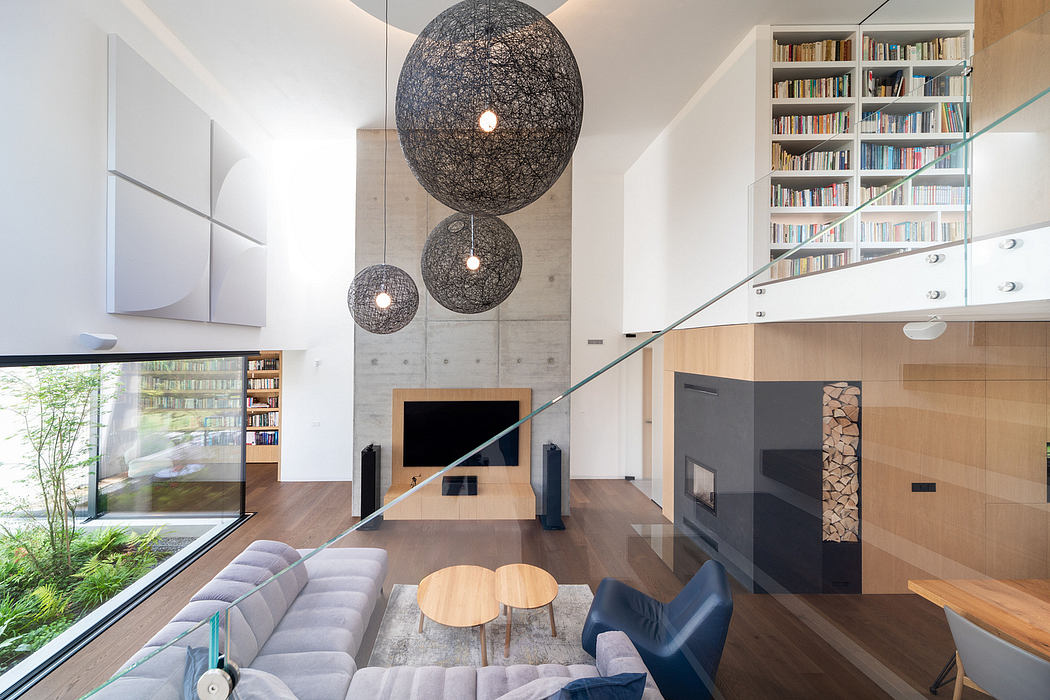 Minimalist living room with modern pendant lighting, glass walls, and a wood-paneled fireplace.