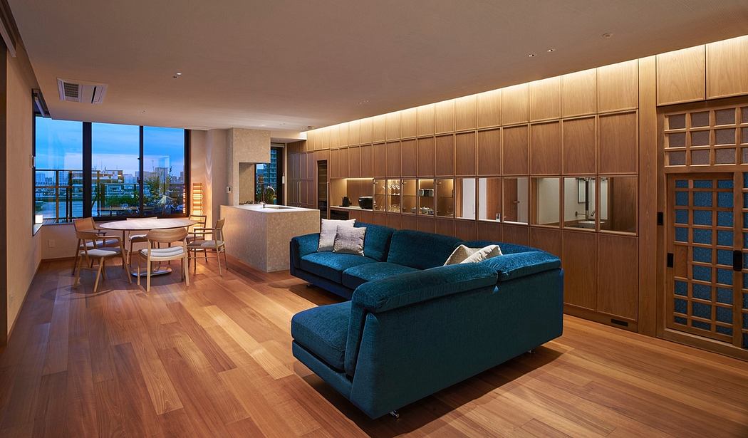 Spacious living room with plush blue sofa, wooden cabinetry, and panoramic city views.