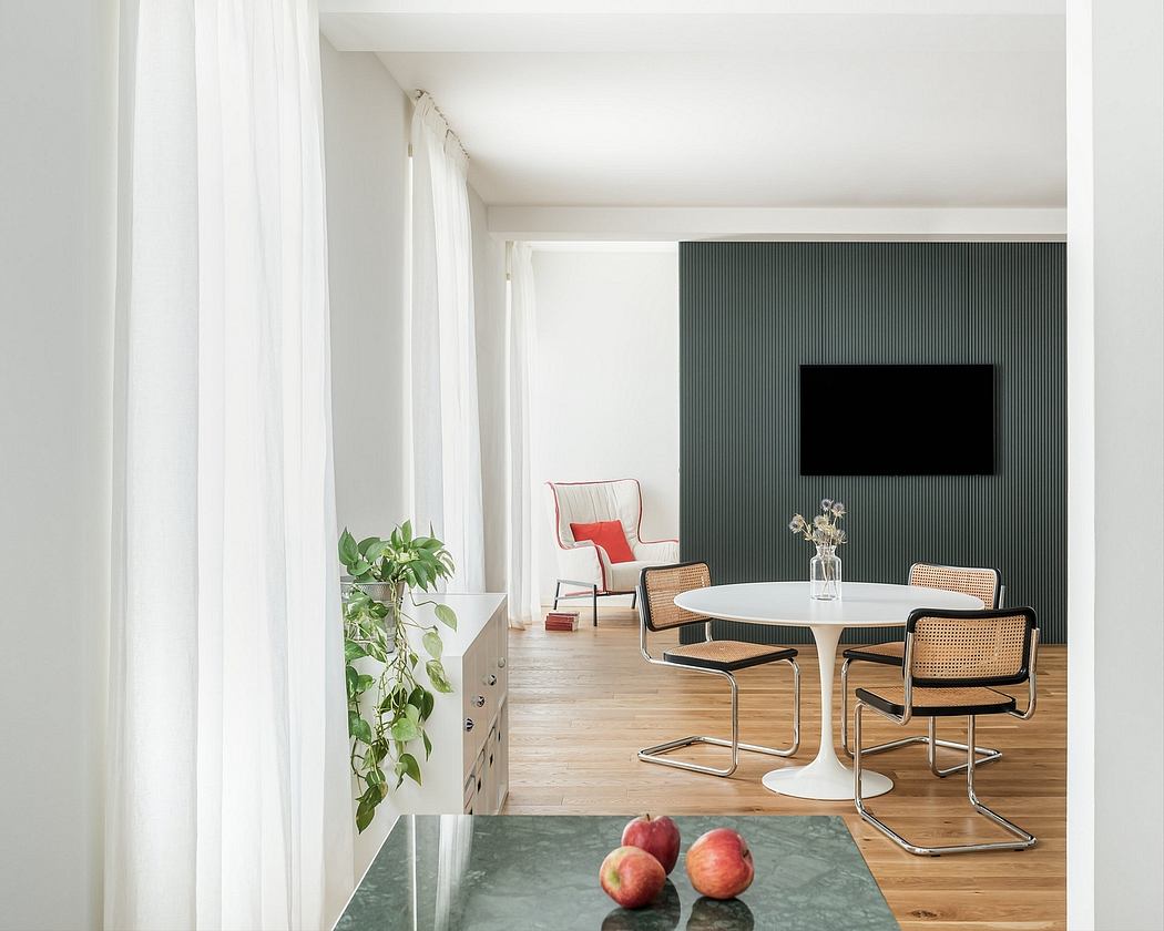 Spacious, minimalist living room with white walls, wood floors, and modern furniture.